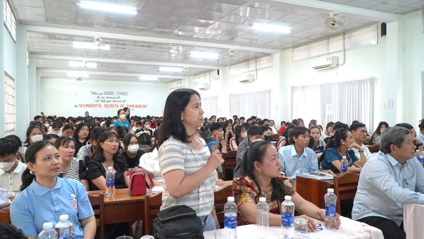 A person standing in front of a large group of peopleDescription automatically generated